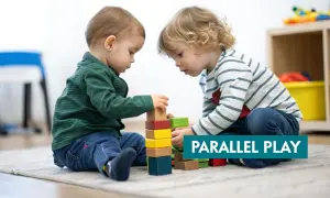 Two toddlers build with blocks, demonstrating the benefits of parallel play.