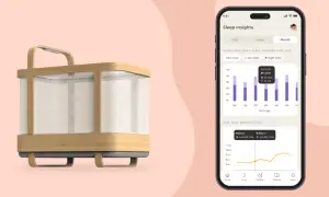 A modern 4 in 1 crib with a phone displaying sleep insights, showing a baby's sleep patterns over time.