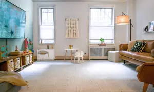 A cozy DIY play room with a brown leather sofa, a small table and chair, and toy storage.