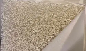 Close-up of a white, airy, woven material, revealing what the Newton mattress is made of: a breathable, open-cell core.