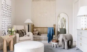 A serene nursery with a gold crib, plush armchair, and elephant stool. This space offers fun nursery ideas with its whimsical decor and cozy atmosphere.