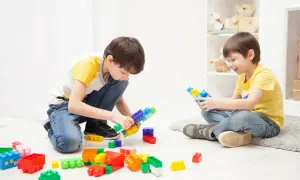 Two boys happily build with colorful blocks, showing great ideas for what to play indoors.