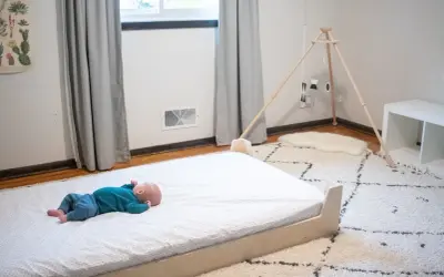 Newborn baby sleeps peacefully on a floor bed.
