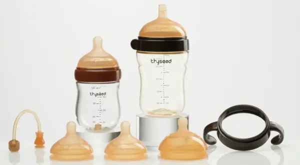 Two baby bottles and accessories. Consider how often to replace plastic baby bottles for safety.