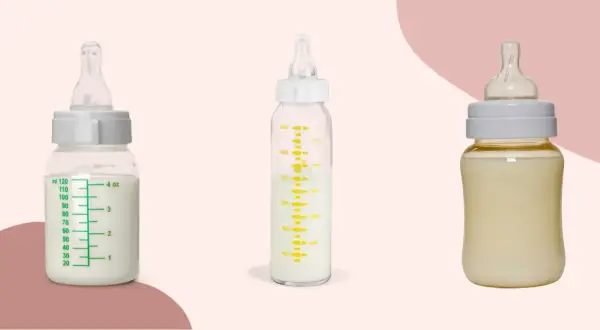 Two glass baby bottles filled with milk sit beside a plastic one, showcasing the difference between glass baby bottles vs plastic.