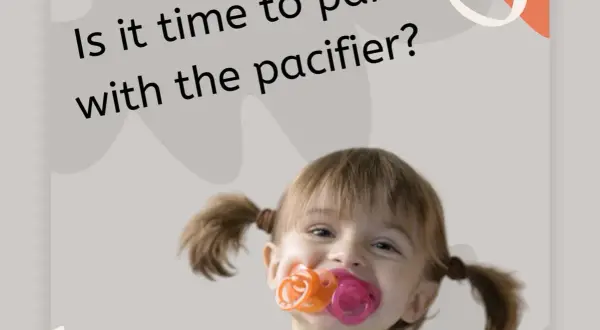 A happy toddler with pigtails is chewing on three pacifiers at once. Is it time to part with the pacifier?