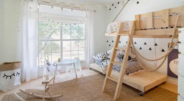 Charming toddler bedroom ideas: a wooden bunk bed, a play table, and a rocking horse create a whimsical space.