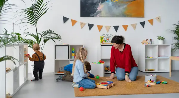 Children engage in independent play, exploring toys and learning materials, embodying the Montessori approach to play.