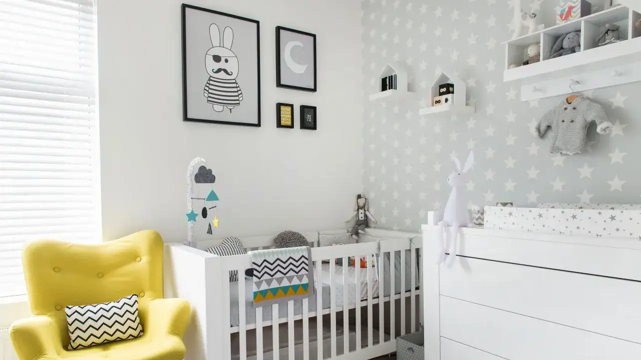 A modern nursery with cute baby boy nursery themes. A yellow armchair, crib with star wallpaper, and playful wall art create a whimsical space.