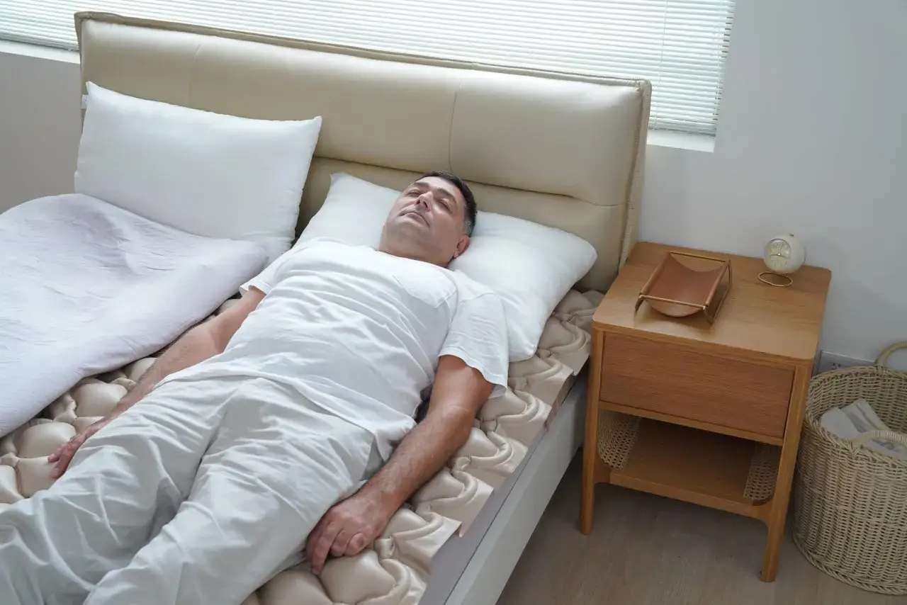 A man sleeps peacefully on a comfortable, breathable mattress. The mattress has a unique design that promotes airflow, ensuring a cool and restful night's sleep.
