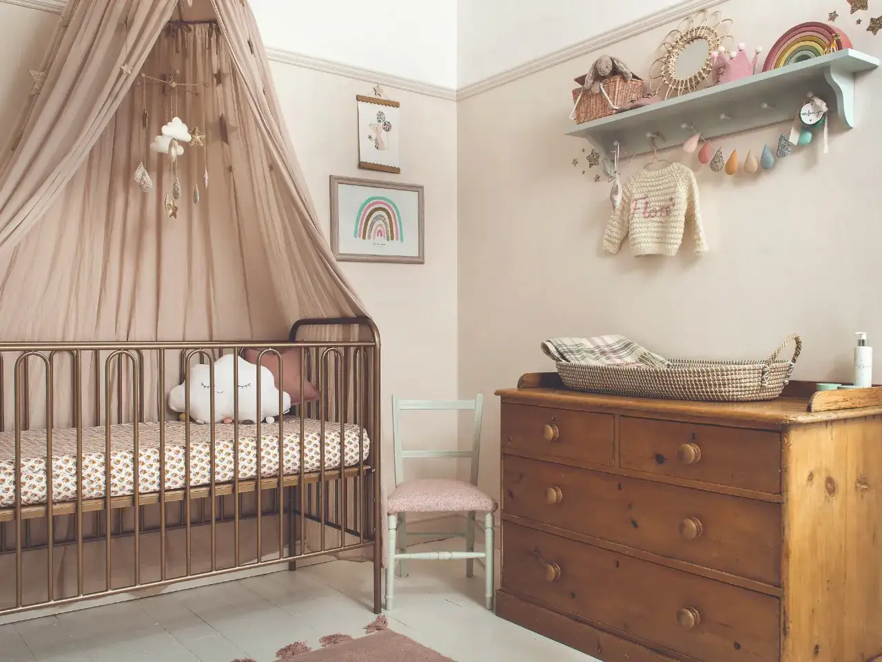 Dreamy nursery with a gold crib, cloud mobile, and rainbow art. Discover cute baby room ideas for a magical space.