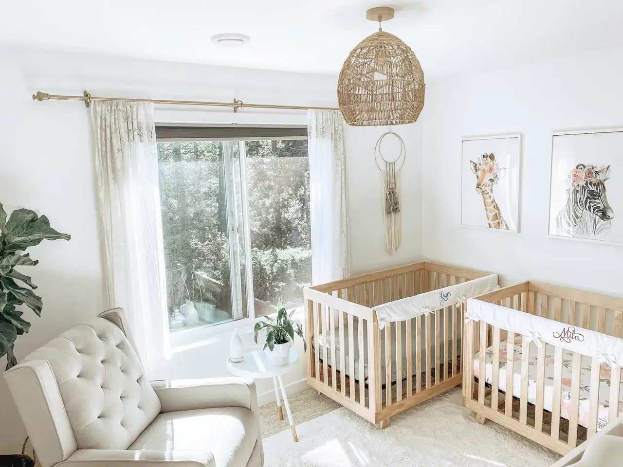 A serene nursery with two wooden cribs, part of twin nursery sets, adorned with floral bedding and personalized name bumpers.