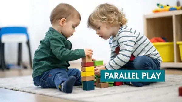 Two toddlers build with blocks, demonstrating the benefits of parallel play.