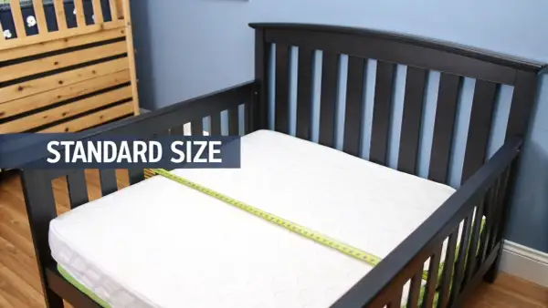 A standard size crib mattress fits perfectly in this toddler bed, showing it does a crib mattress fit a toddler bed.