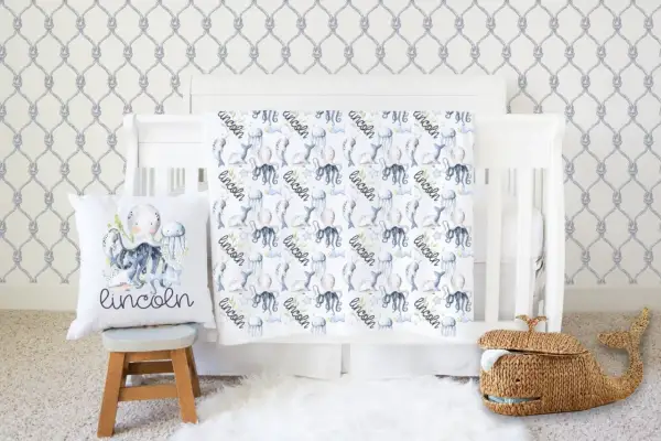 Nautical nursery with under the sea crib bedding sets featuring octopuses, narwhals, and jellyfish. A whale basket sits nearby.