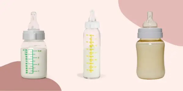 Two glass baby bottles filled with milk sit beside a plastic one, showcasing the difference between glass baby bottles vs plastic.