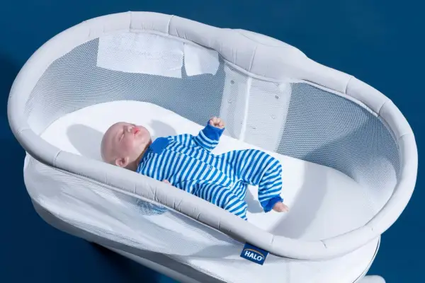 A baby doll sleeps soundly in a Halo bassinet, a safe and stylish alternative to traditional cribs.