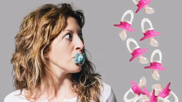 A woman with a binkie mouth looks surprised as pink pacifiers fall around her.
