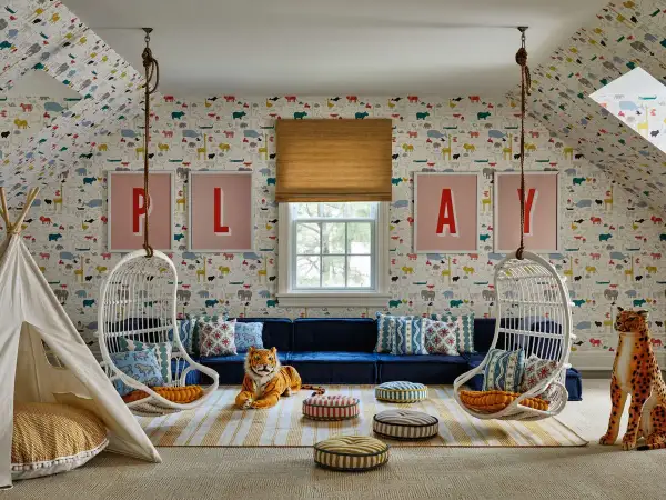 A whimsical playroom set up with animal wallpaper, hanging chairs, a teepee, and plush toys.