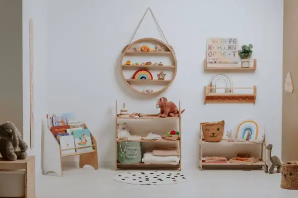 A serene nursery showcasing Montessori organization at home. Wooden shelves display books, toys, and soft blankets, creating a calm and inviting space for a child.